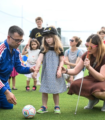 Frankfurt, GERMANY - JUNE 23: (L-M) Xrisostomos Kasamakis guides Emma Appel towards the ball with the assistance of the mother at The Ball For All campaign at the official UEFA Fan Zone during the UEFA EURO 2024 Group A match between Germany and Switzerland on June 23, 2024 in Frankfurt, Germany.(Photo by Neil Baynes - UEFA/UEFA via Getty Images)